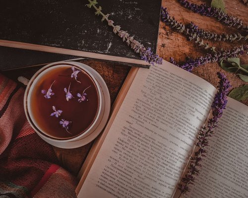 A soothing cup of herbal tea resting on a wooden table beside an open journal